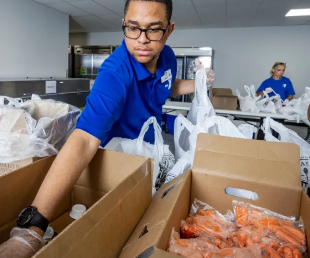 Nick reaching into box to grab item for meal